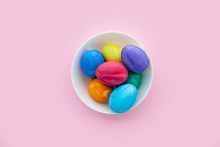 White eggs on pink background. Colorful eggs on the plate. Easter preparation.の写真素材