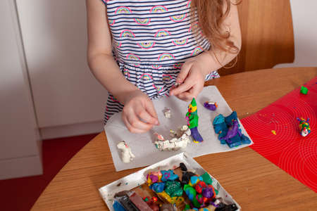 7 years old baby craft with plasticine in the kitchen. Home interior. Home education.の写真素材