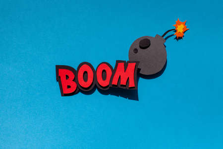 Handmade paper speech bubble on blue background. Cartoon and pop art style. Boom text. Expression. Bomb.の写真素材