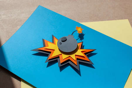 Handmade colorful paper cutting bomb. Pop art and comic style. On blue background. Cartoon and flat.