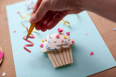 Paper cutting cupcake on blue background. Handmade art work. Colorful sprinkles, dot and star, for your birthday card design.の写真素材