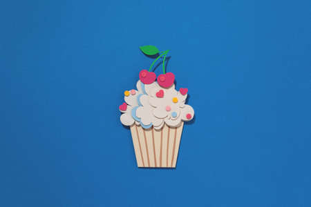Paper cutting cupcake on blue background. Handmade art work. Colorful sprinkles, dot and star, for your birthday card design. Confetti.の写真素材