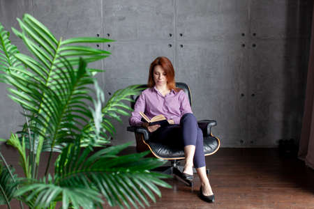 Young caucasian women reading a book at home. Office worker. Remote. Online education.