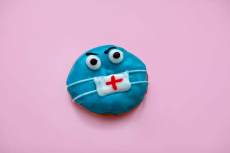 Blue donut. Face in the mask. Modern sweet food. Pink background.