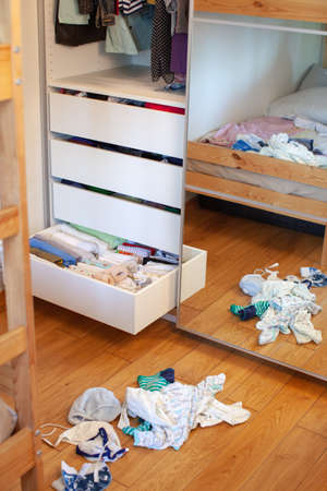 Vertical storage of clothing. Clothing folded for vertical storage in the linen drawer. Preparing. Sliding wardrobe. Room interior. Neatly folded clothes in chest of drawers. Newborn.の写真素材