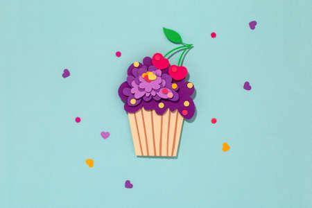 Paper cutting cupcake on blue background. Handmade art work. Colorful sprinkles, dot and star, for your birthday card design. Confetti.の写真素材