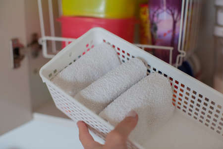 Storage in the kitchen. Towel organization in white basket.の写真素材