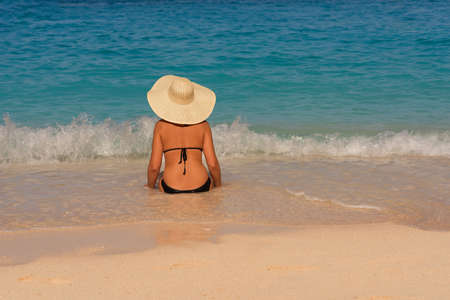 Young beautiful woman in swimsuit and hat relaxing on Navagio beach, Zakynthos island, Greeceのeditorial素材