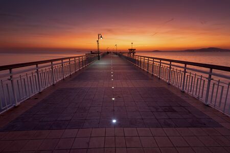 Dramatic sunrise on the beach in Burgas, Bulgaria. Sunrise on the Burgas Bridge. Bridge in Burgas - symbol of the city.の写真素材