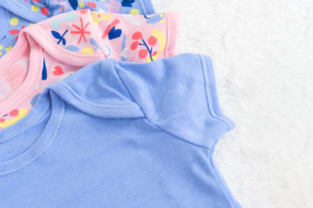 Bodysuits for baby girl and a toy on a white fur carpet. Newborn Baby Concept. Baby Girl Clothes Set.の写真素材