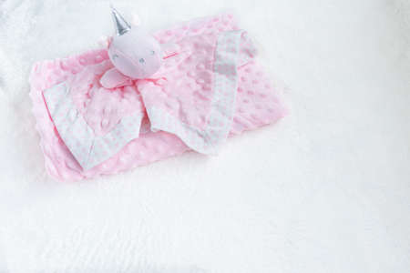 Pink blanket for baby girl and toy on a white fur carpet. Newborn Baby Concept. Baby Girl Clothes Set.の写真素材