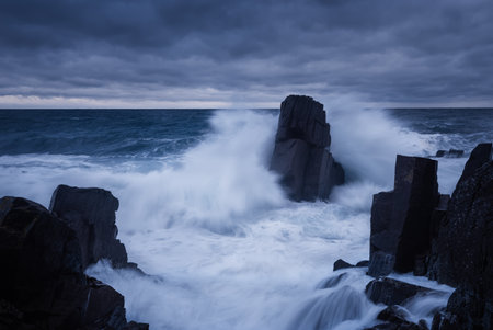 Big waves and dark rock in stormy sea, stormy weather.の写真素材