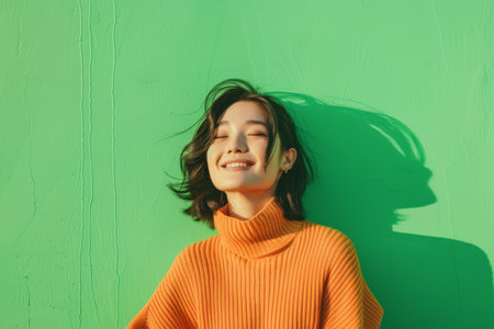 Happy woman standing on green background with trendy styleの素材