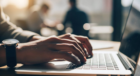 Cropped image of female hands typing on laptop keyboard while sitting in cafeの素材