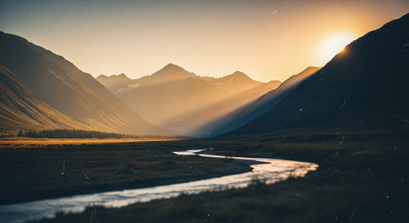 A serene landscape featuring a winding river flowing through a valley surrounded by majestic mountains at sunset, with warm light illuminating the sceneの素材