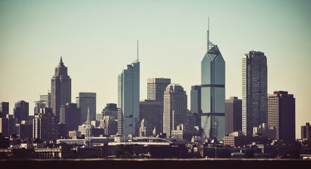 A panoramic view of a modern city skyline featuring tall skyscrapers and a clear blue skyの素材