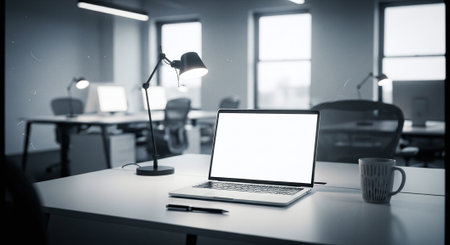 Mockup image of laptop with blank white screen on table in modern officeの素材