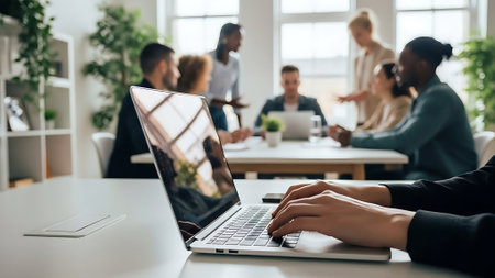 Cropped image of businesswoman using laptop while sitting at table in officeの素材