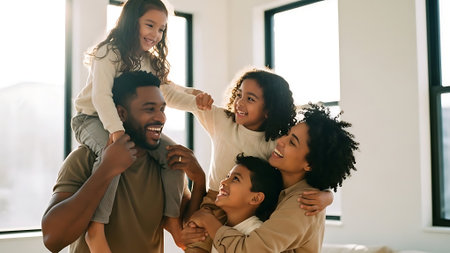 happy african american family piggybacking in living room at homeの素材