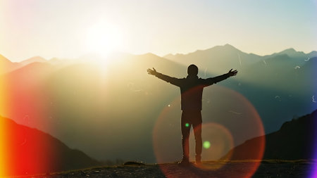 Silhouette of a man with open arms against the background of the mountainsの素材