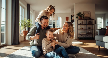 A happy family of four enjoying quality time together in their modern living roomの素材