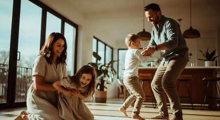A happy family of four enjoying a fun moment together indoorsの素材