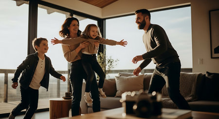 Happy family playing together at home. Mother, father and their children having fun together.の素材