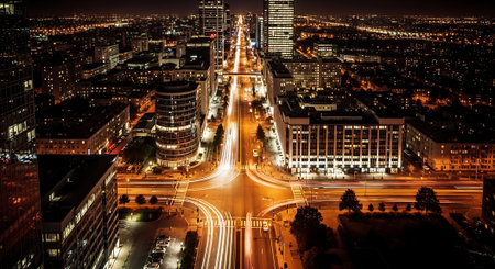 Aerial view of a bustling city at night with illuminated streets and skyscrapersの素材