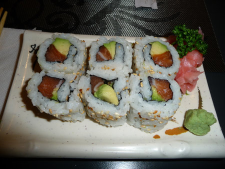 Sushi roll with salmon, avocado and cucumber on white plateの写真素材