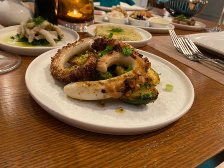 Fried octopus on a white plate on a wooden tableの写真素材