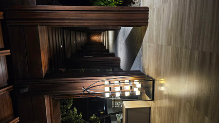 A resort hallway at night with a candle lamp, wooden columns, and atmospheric lighting.の写真素材