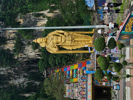 June 1, 2023, Kuala Lumpur, Batu Caves, Malaysia. Climbing the 272 steps rainbow stairs at the sacred Batu Caves Hindu temple next to the golden statue of Lord Murugan in Malaysia.のeditorial素材