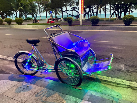 Illuminated Cycle Rickshaw (Cyclo) Parked on City Street at Night
