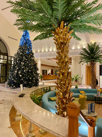 January 2, 2023, Sharm-El-Shaykh, Egypt. Elegant festive interior featuring a decorated Christmas tree and palm trees with fairy lights in a tropical resort.のeditorial素材