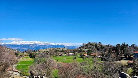 Panoramic view of snow-capped Taurus mountains and green rural landscape in Antalya, Turkey. Scenic...