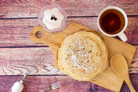 Breakfast with pancakes and tea. Kefir pancakes on wooden background.Top view.の写真素材