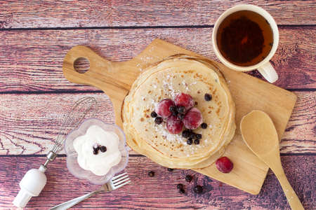 Breakfast with pancakes and tea. Kefir pancakes decorated with different berries.Top view.の写真素材