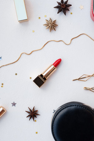 Luxury female beauty products set: cosmetic bag, red lipstick, hair accessory from above on white background. Christmas Beauty Presents. For luxury beauty brands and fashion blogs. Flatlay style.の写真素材