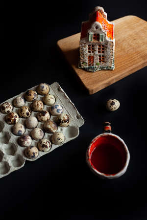 Breakfast with quiel eggs and red tea on a black brackground. Ceramic art. Sculpture Miniature Candle House.の写真素材