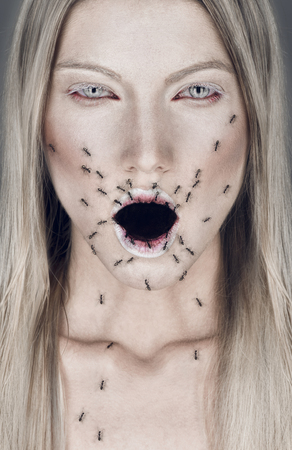 Portrait of blond woman with open mouth and antsの写真素材