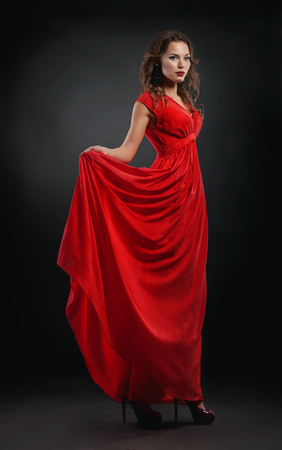 Portrait of beautiful woman in red dress with red lipsの写真素材