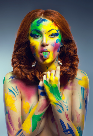 Funny woman with painted colorful body-artの写真素材