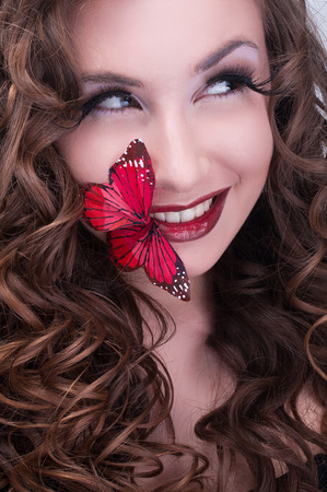 Redhead curly woman with red butterfly on lipsの写真素材