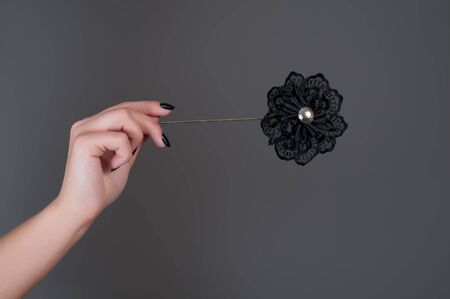 Black artificial flower in woman's handの写真素材