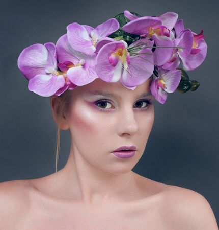 Beautiful young woman with lilac flowers in hairの写真素材