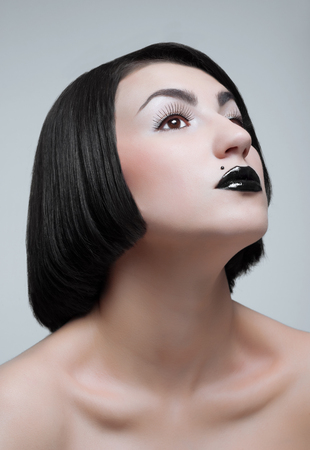 Studio portrait of young brunette with black lipsの写真素材