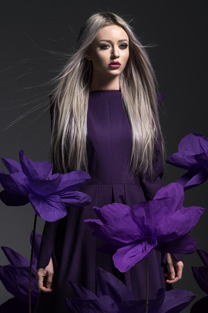 Young beautiful woman in dress on dark backgroundの写真素材