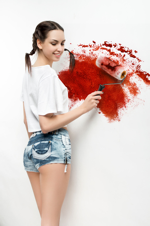 Young beautiful Girl painting the walls into bloody red colorの写真素材