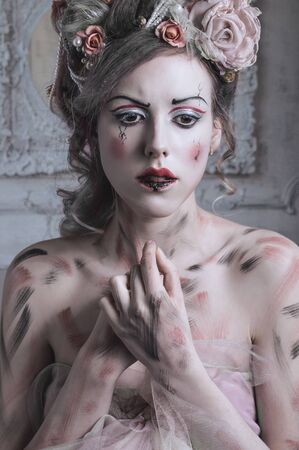 Girl in purple dress and flowers in hair posing in old roomの写真素材