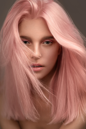 Portrait of beautiful woman with pink hair looking at cameraの写真素材